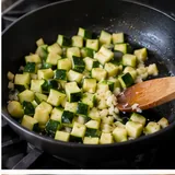 Dés de courgette et ail cuisant dans une poêle