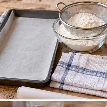 Gâteau roulé à la confiture : préparer plaque et four, plaque chemisée et torchon prêt.