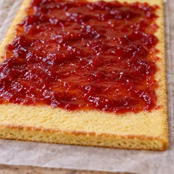 Gâteau roulé à la confiture : dérouler et garnir, garniture étalée avec une bordure libre.