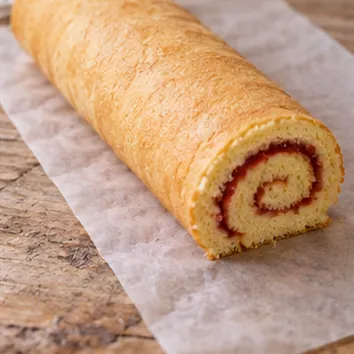 Gâteau roulé à la confiture : rouler sans emprisonner le papier, roulé fermé, jointure dessous, sans papier intérieur.