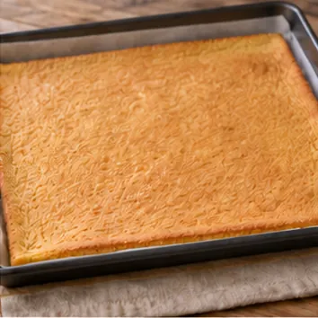 Gâteau roulé au chocolat : étaler et cuire, biscuit souple, légèrement doré.