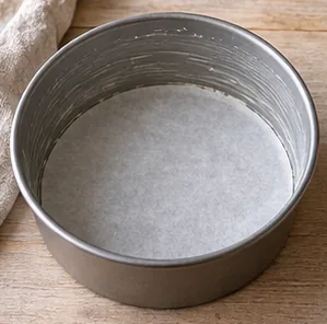 Gâteau à l’orange : préparer le four et le moule — Moule beurré et chemisé.