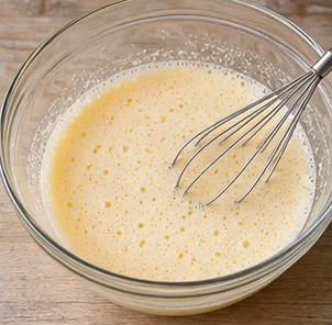 Gâteau à l’orange : fouetter les œufs et le sucre — Œufs et sucre légèrement mousseux.