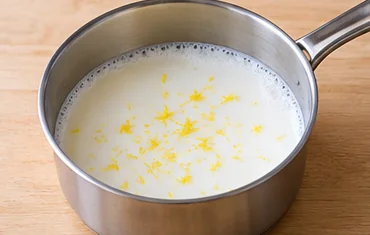 Gâteau à la semoule et au citron : chauffer le lait parfumé — Lait frémissant, sans débordement.