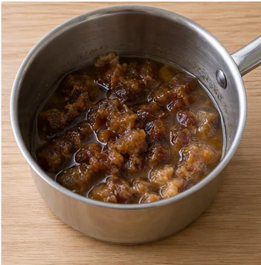 Gâteau aux dattes : assouplir les dattes — Dattes tendres dans leur liquide, mélange tiédi.
