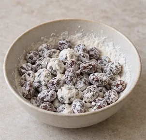 Fariner légèrement les raisins : Raisins séparés par un fin enrobage de farine.