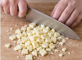 Couper le chocolat blanc : Morceaux de chocolat blanc de 5 à 8 mm.