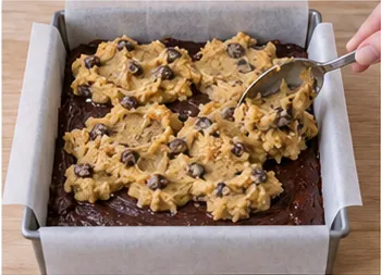 Répartir le cookie sur le brownie : Couche cookie répartie sur la couche chocolat.