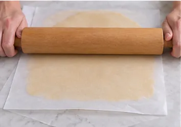 Étaler la pâte entre deux papiers : Épaisseur régulière, pâte encore ferme.