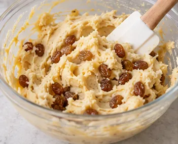 Incorporer la farine puis les raisins : Pâte souple garnie de raisins.