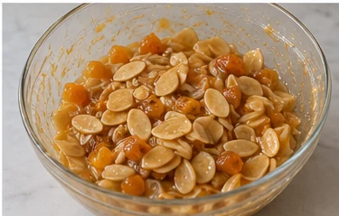 Ajouter les amandes et l’orange : Amandes enrobées, orange bien répartie.