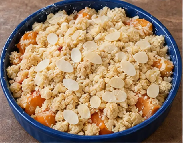 Miettes et amandes effilées réparties sur les abricots.
