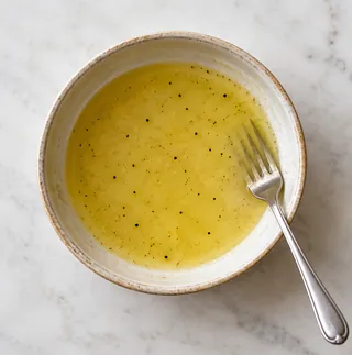 Émulsionner la vinaigrette : préparation de carottes râpées au citron